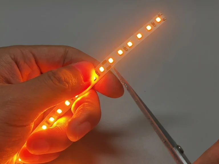 Ligne de coupe de bande LED montrant l'icône des ciseaux, la ligne pointillée et les pads en cuivre exposés entre les segments LED